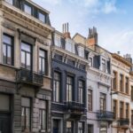 Rangée de maisons de ville bruxelloises dont les corniches couronnent le haut des façades